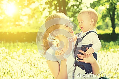 Happy baby girl in a wreath on meadow with yellow flowers on t Stock Photo