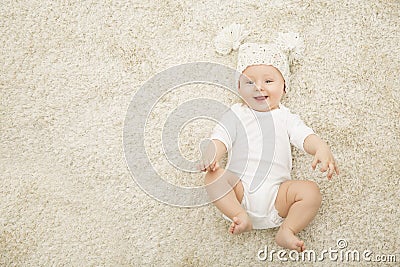 Happy Baby in Hat and Diaper Lying on Carpet Background Stock Photo