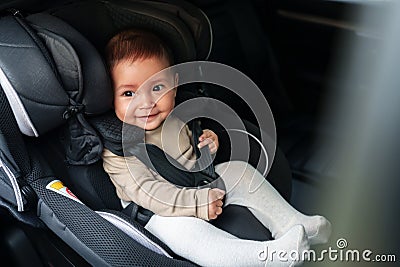 happy baby sitting in infant car seat, safety chair travelling Stock Photo