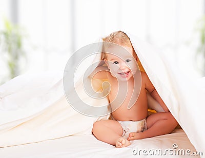 Happy baby under a blanket laughing Stock Photo