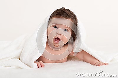 Happy baby under towel on white Stock Photo