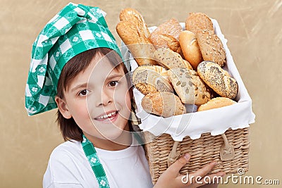 Happy baker boy holding basket with fresh bakery products Stock Photo