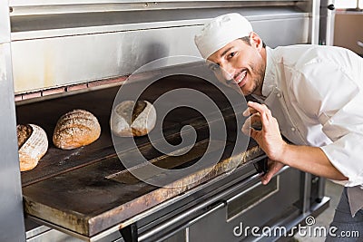 Happy baker by open oven Stock Photo