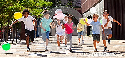 Happy with balloons run on the summer city street Stock Photo