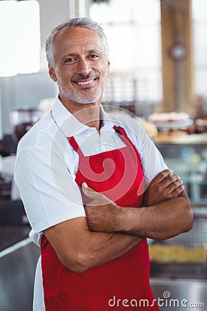 Happy barista smiling at camera with arms crossed Stock Photo