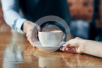 happy bartender serving a cup of coffee to a patient in a cafe drink brick wall interior Stock Photo