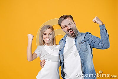 Happy bearded man in casual clothes have fun with child baby girl. Father little kid daughter isolated on yellow Stock Photo