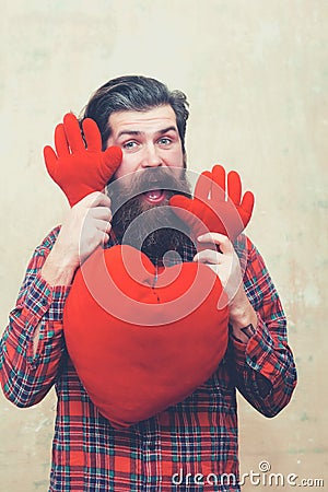 Happy bearded man holding red heart shape toy with hands Stock Photo