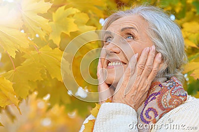 Happy beautifil elderly woman posing in autumn park Stock Photo