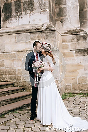 Happy beautiful couple. bride in a wreath of fresh flowers on the street Stock Photo