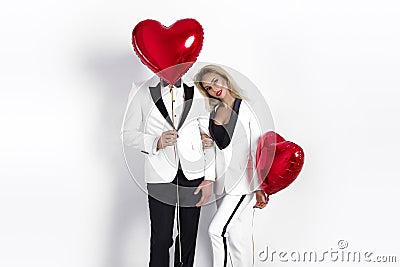 Happy beautiful couple posing on white background and holding balloons heart. Valentine`s day. Stock Photo