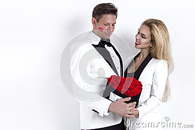 Happy beautiful couple posing on white background and holding flower box with red heart. Valentine`s day, wedding. Stock Photo