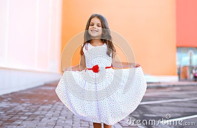 Happy beautiful little girl shows white dress and having fun Stock Photo