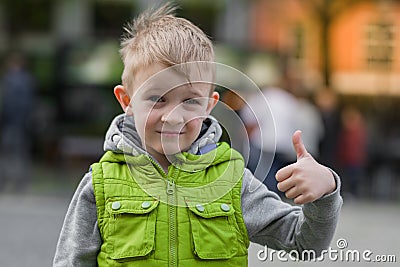 Happy little stylish blonde boy show ok sign, looking at camera Stock Photo