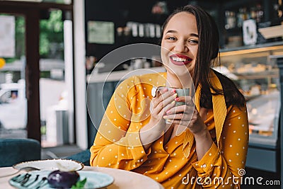 Happy beautiful plus size woman smiling and drinking coffee in cafe Stock Photo