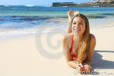 Happy beautiful smiling woman enjoying relax lying on the beach looking to the side. Summer holidays concept Stock Photo
