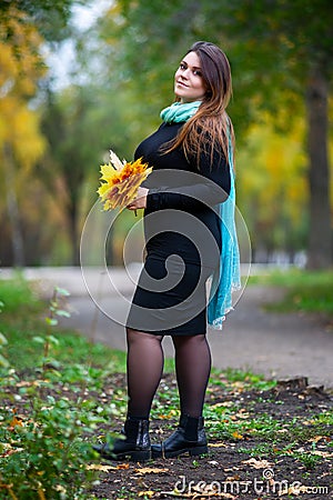 Happy beautiful woman in autumn, cute plus size model outdoors, full length portrait Stock Photo
