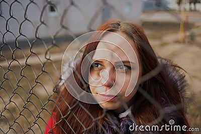 Happy beautiful young girl in a red jacket posing outside on a cloudy day Stock Photo