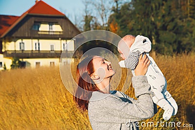 Happy beautiful young mother with her baby child on nature. Stock Photo