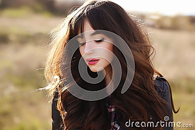 Happy beautiful young woman with long black healthy hair enjoy fresh air and sun light outdoor at sunset. Stock Photo