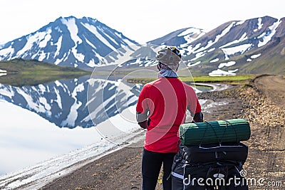 Happy biker on backdrop of lake and snowing mountains in Iceland Stock Photo