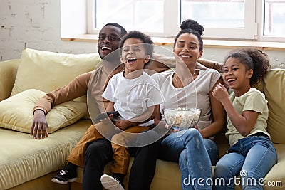 Happy biracial family with kids watching TV together Stock Photo