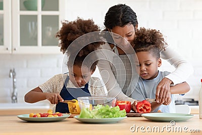 Happy biracial kids involved in preparing food with mum. Stock Photo