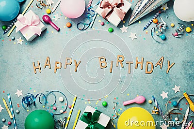 Happy birthday banner. Colorful holiday supplies on blue vintage table top view. Flat lay style. Stock Photo