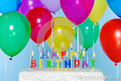 Happy Birthday candles on cake with balloons Stock Photo