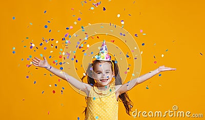 Happy birthday child girl with confetti on yellow background Stock Photo