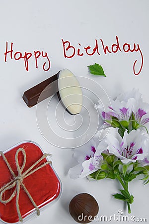 Happy birthday greeting card with gift box, fresh flowers and chocolates Stock Photo