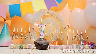 Happy birthday greetings for a 7-year-old child from golden letters of candles burning against the background of mine-space Stock Photo