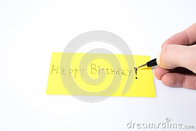 Happy birthday handwrite with a pen and a hand on a yellow paper Stock Photo