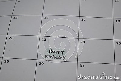 Happy Birthday text on monthly Calendar and marked 23th isolated on office desk Stock Photo