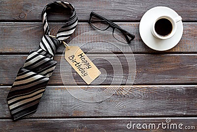 Happy birthday text near male tie on dark wooden background top view copy space Stock Photo