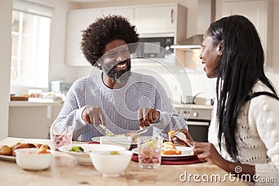 Happy black couple enjoying eating their Sunday dinner together at home, close up Stock Photo