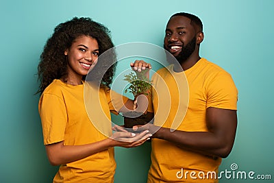 Happy couple protect a small tree. Concept of forestation, ecology and conservation Stock Photo