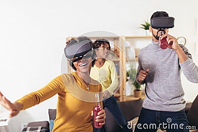 Black family at home. Dad, mom and daughter playing virtual reality Stock Photo