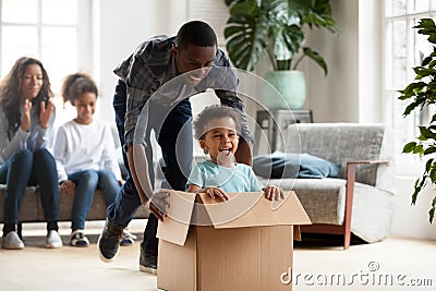 Happy black family play with kids moving to new home Stock Photo