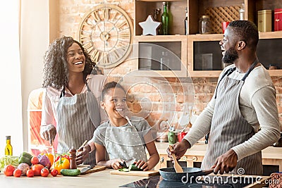 Happy black family of three laughing at kitchen Stock Photo