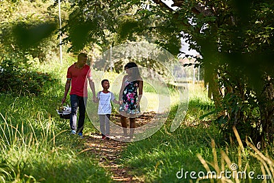 Happy Black Family Walking In City Park With Picnic Basket Stock Photo