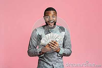 Happy black man in african shirt holding bunch of money Stock Photo