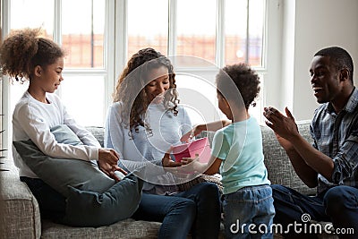 Happy black mom receiving gift box with present from son Stock Photo