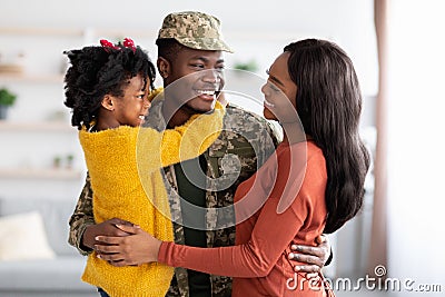 Happy Black Wife And Daughter Welcoming Military Father At Home After Army Stock Photo