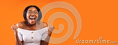 Happy Black Woman Screaming Shaking Fists Standing, Orange Background, Panorama Stock Photo