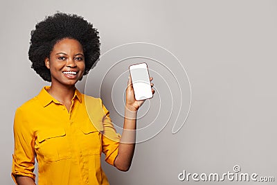 Happy black woman showing empty blank screen display smart phone against white studio wall background Stock Photo