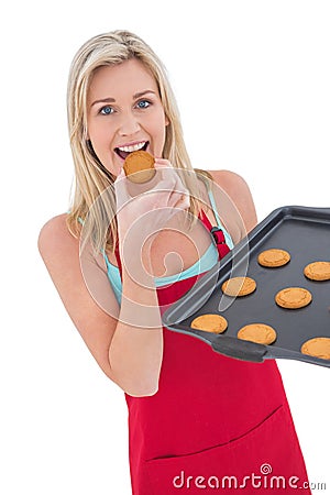 Happy blonde eating hot cookies Stock Photo