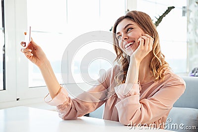 Happy blondy woman in blouse sitting by the table Stock Photo