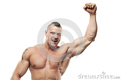 Happy bodybuilder enjoying victory. Smiling shirtless excited muscular healthy young man in good shape with hand in fist. Stock Photo