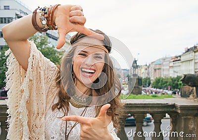 Happy bohemian woman tourist framing with hands in Prague Stock Photo